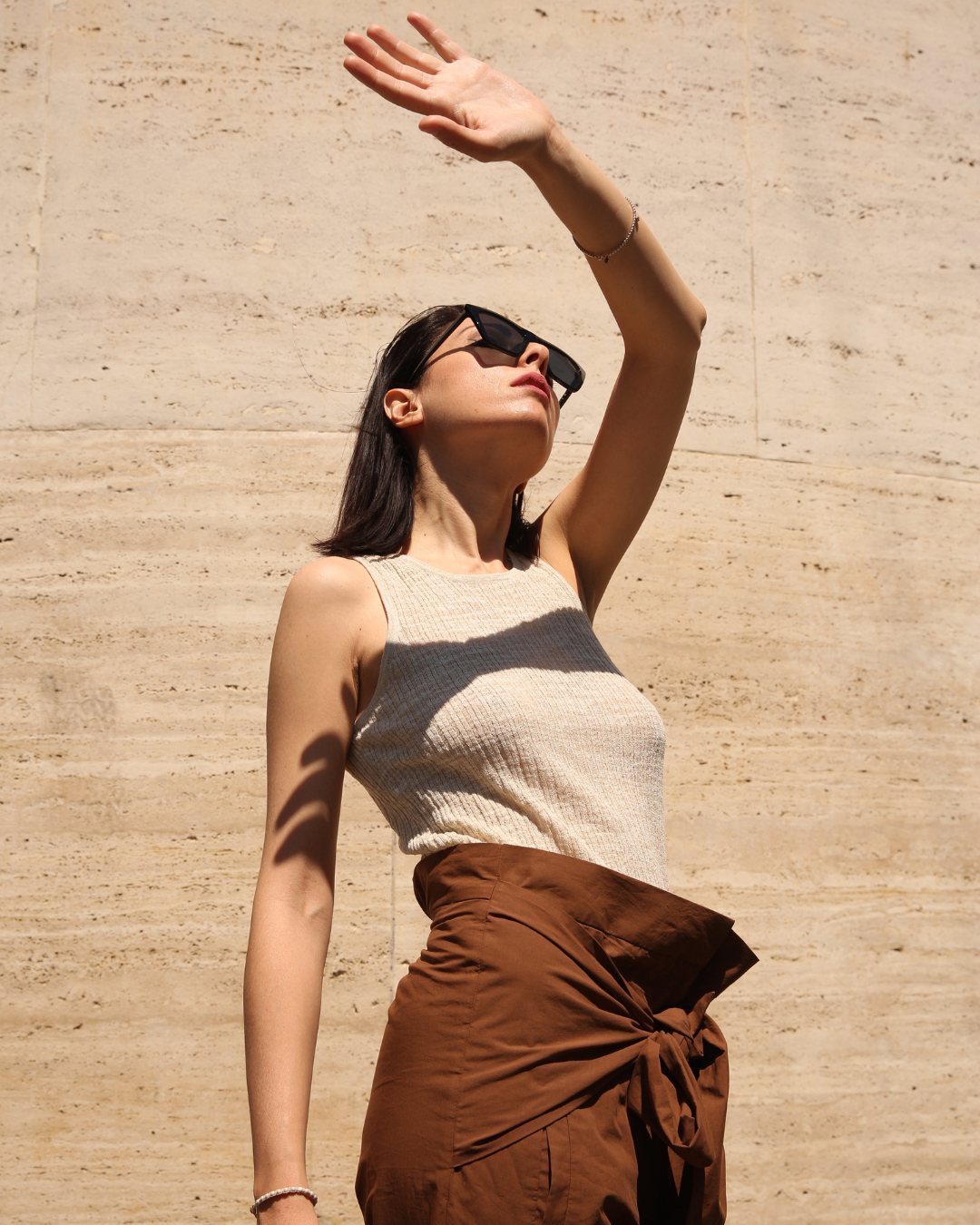 silhouette féminine au soleil levant le bras 