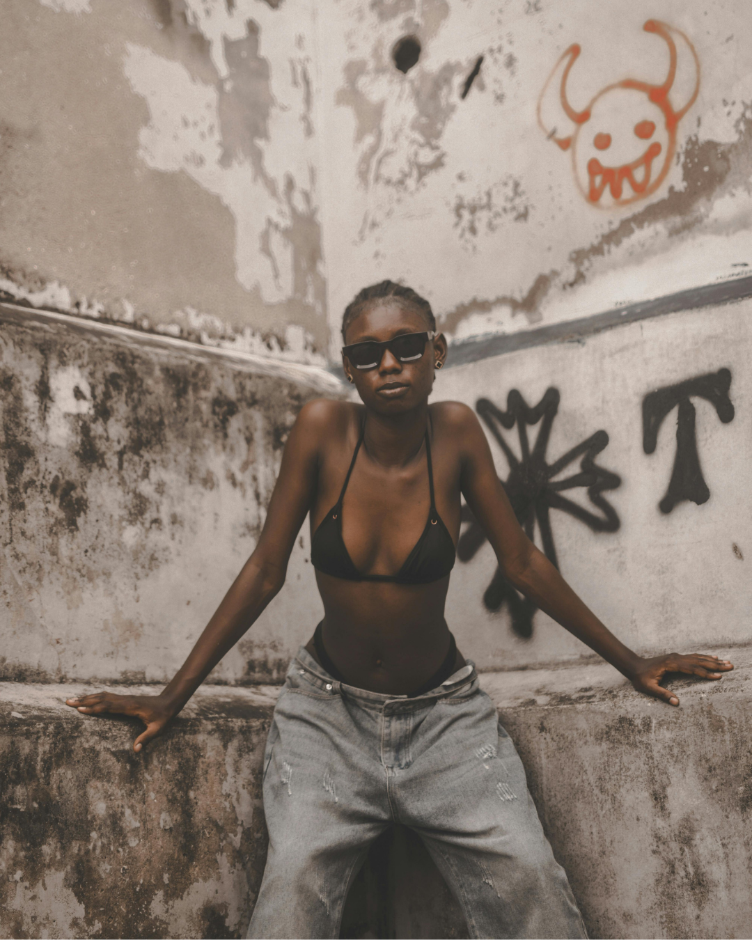 femme mince posant sur un mur tagué 